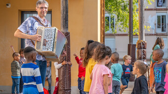 Un accordéoniste joue devant les élèves dans la cour de récréation pour la rentrée en musique