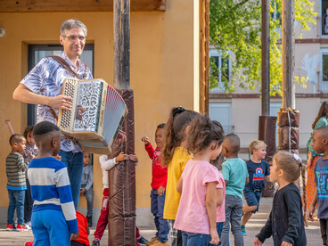 Un accordéoniste joue devant les élèves dans la cour de récréation pour la rentrée en musique